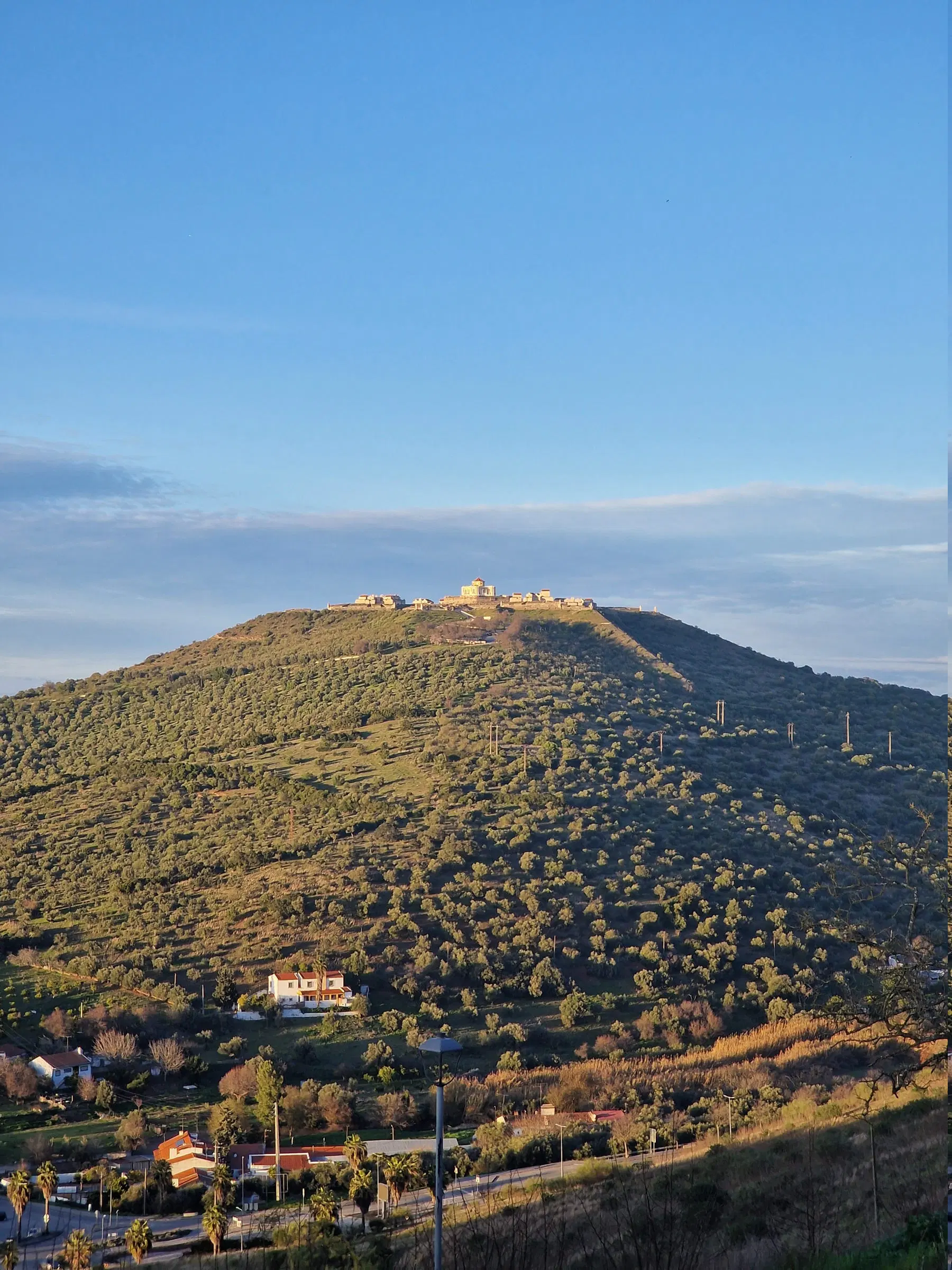 Vista aérea de Elvas, com a colina fortificada a destacar-se sobre a planície coberta de mato.