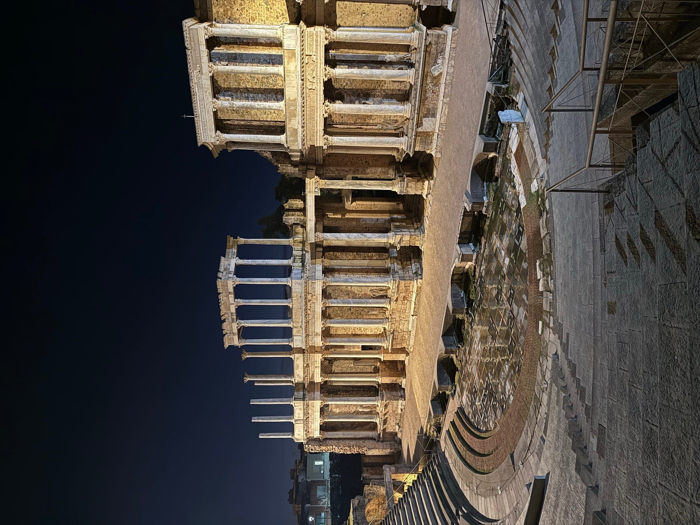 The Roman theatre of Mérida lit up, its two tiers of columns on the stage front.